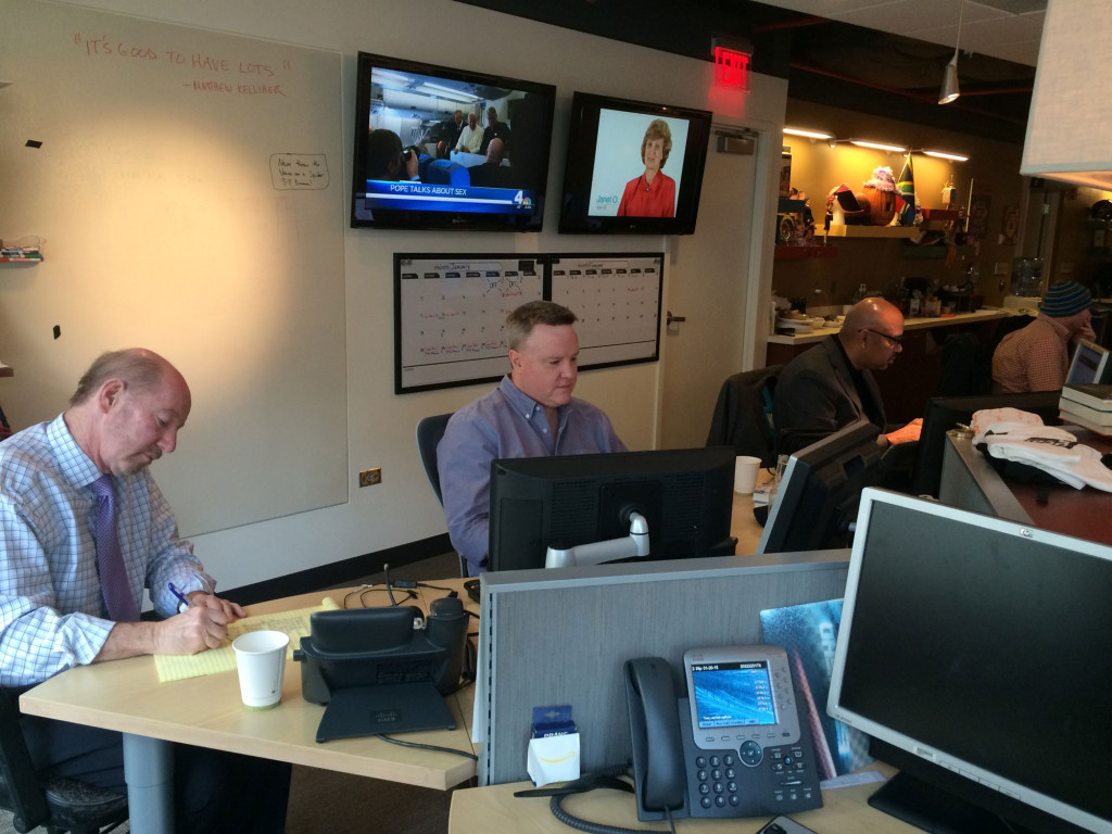 (From left) Kornheiser, Kelliher and Wilbon run through the day's topics prior to taping. (WTOP/Noah Frank)