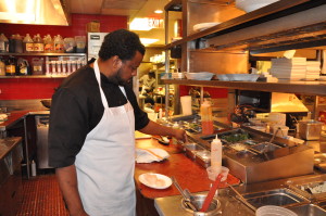 Dane Sewlall, executive chef at Black’s Bar & Kitchen, preps the local Maryland scallops. (WTOP/Rachel Nania)