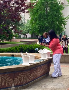 A family places a flower at the Washington Area Law Enforcement Officers Memorial in D.C. (WTOP/Megan Cloherty)