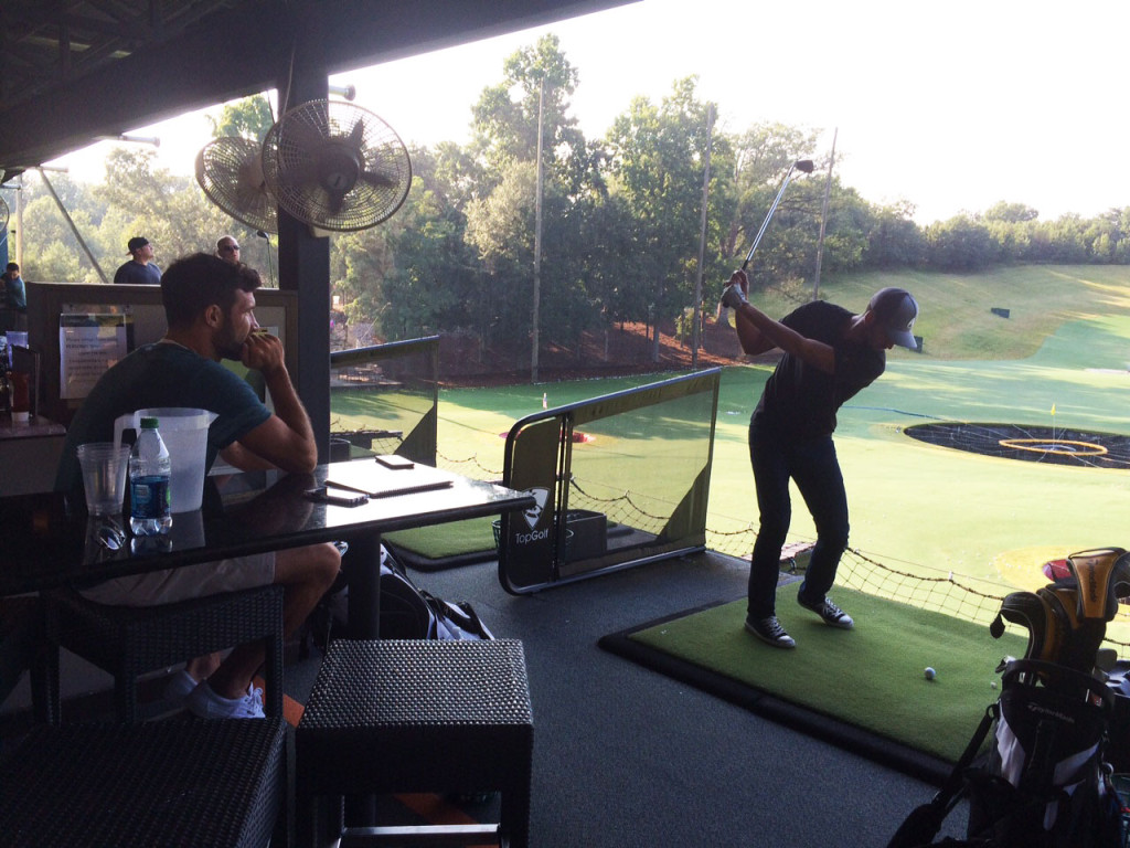 Pontius watched while Birnbaum plays a shot at the Topgolf in Alexandria. (WTOP/Noah Frank)
