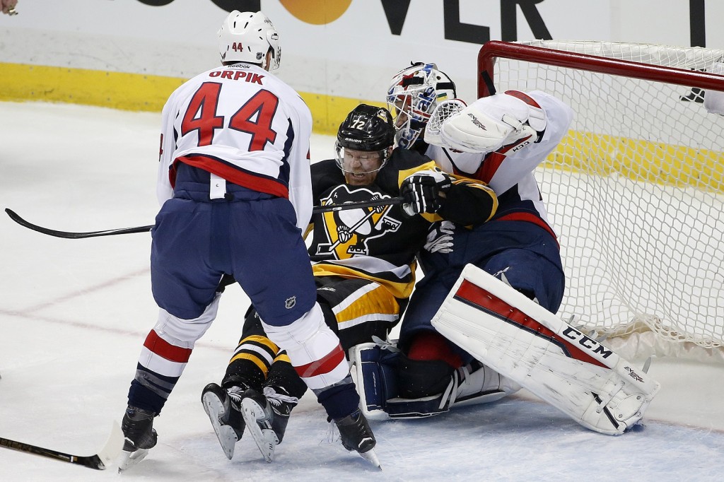 Washington Capitals' Brooks Orpik (44) checks Pittsburgh Penguins' Patric Hornqvist (72) into goalie Braden Holtby (70) during the first period of an NHL hockey game in Pittsburgh, Sunday, March 20, 2016. (AP Photo/Gene J. Puskar)