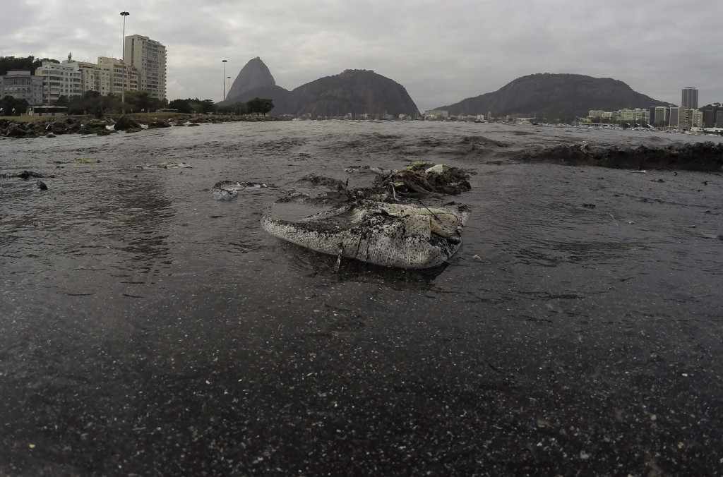 Thrash floats on the water of Botafogo beach next to the Sugar Loaf mountain and the Guanabara Bay. (AP Photo/Leo Correa)