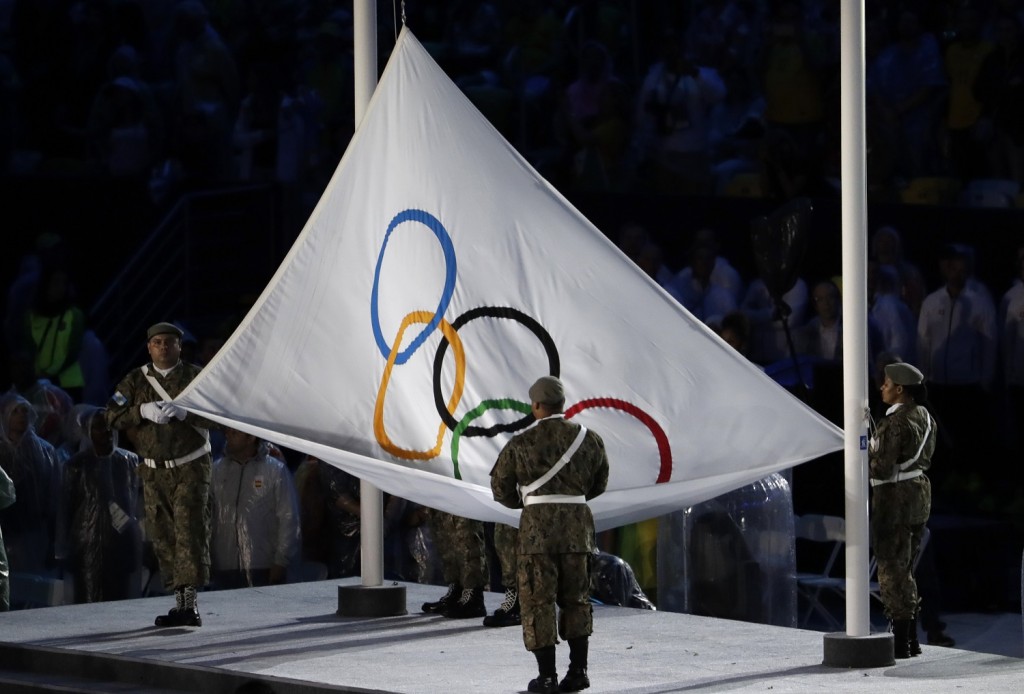 Soldiers lower the Olympic flag during the closing ceremony in the Maracana stadium. (AP Photo/Natacha Pisarenko)