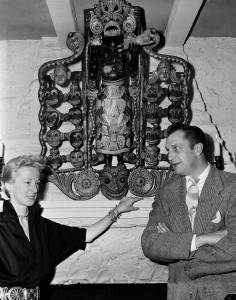 Victoria's parents, Vincent and Mary Price in their Benedict Canyon, Calif., home, with a carving of the African God of Disease which hung over their fireplace,  1950 (AP)