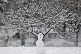 A snowman made by children is backdropped by trees covered in snow in  a park in Bucharest, Romania, Monday, Dec. 29, 2014. Romania, especially the eastern part,  is affected by heavy snow falls and blizzards this year  that cause traffic disruptions but are enjoyed by children and mountain tourists. (AP Photo/Vadim Ghirda)