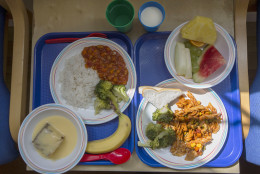 Two lunch trays at a primary school in London are served during a lunch break on Tuesday, May 6, 2014. The meal choice at right consists of pasta with fresh broccoli and slices of bread, and seasonal fresh fruit. At left are vegetable chili with rice and fresh broccoli, sponge cake with custard, and a banana. The drink options are milk and water. (AP Photo/Sang Tan)