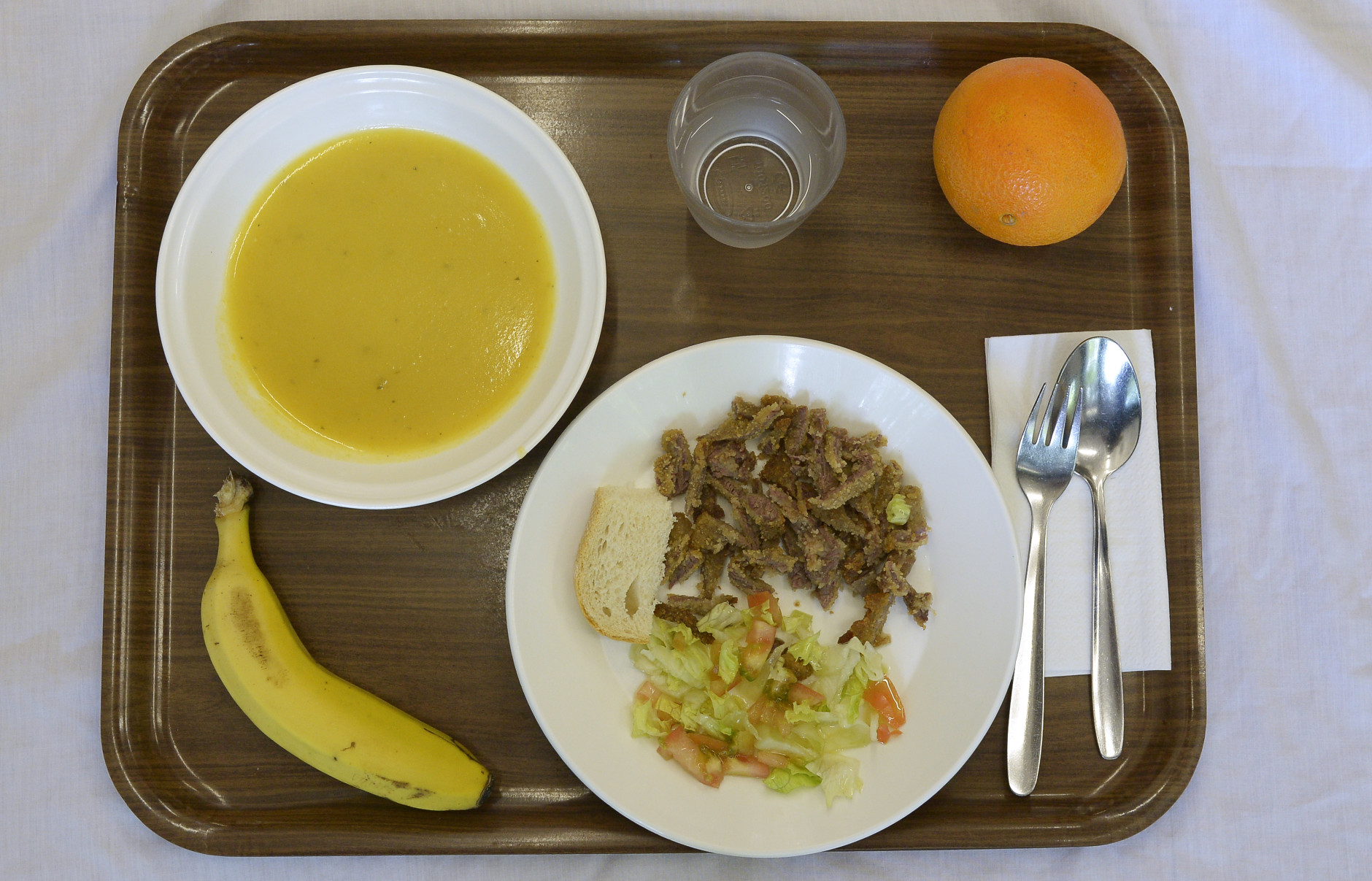 A school lunch at El Caminet del Besos kindergarten is pictured in Barcelona, Spain, Tuesday, May 6, 2014. The lunch is composed of cream of vegetable soup, pan-fried breast of veal with salad, a piece of bread, an orange or banana and water. Most countries seem to put a premium on feeding school children a healthy meal at lunchtime. U.S. first lady Michelle Obama is on a mission to make American school lunches healthier too. (AP Photo/Manu Fernandez)