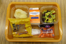 A school lunch featuring a grilled cheese sandwich on whole grain bread is served with a southwestern-style corn salad, fresh carrots and either canned pears or apple sauce Monday, May 5, 2014, at Mirror Lake Elementary School in Federal Way, Wash., south of Seattle. On this day, students could choose between this lunch or a green salad entree option featuring low-sodium chicken, a whole-grain roll, fresh red peppers, and cilantro dressing. (AP Photo/Ted S. Warren)