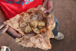 Mamadou Diagana, shows his fried donuts as he makes his way to school in Bamako, Mali, Tuesday, May 6, 2014. In Malis capital, the majority of students go to neighborhood schools and return home from noon to 3 p.m. so they can eat lunch with their families. The they then return to class until 5 p.m. (AP Photo/Baba Ahmed)