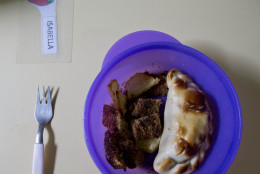 A plastic plate containing an empanada of meat, milanesa (meat covered with egg and bread), and potato is set on a table where children ages 2 to 5 years old have lunch at a school in Buenos Aires, Argentina, Tuesday, May 6, 2014. In Argentina, most children have been able to count on some relative providing a hot homemade lunch before or after they attend public school, which is generally taught in four-hour shifts in the morning or afternoon. (AP Photo/Natacha Pisarenko)