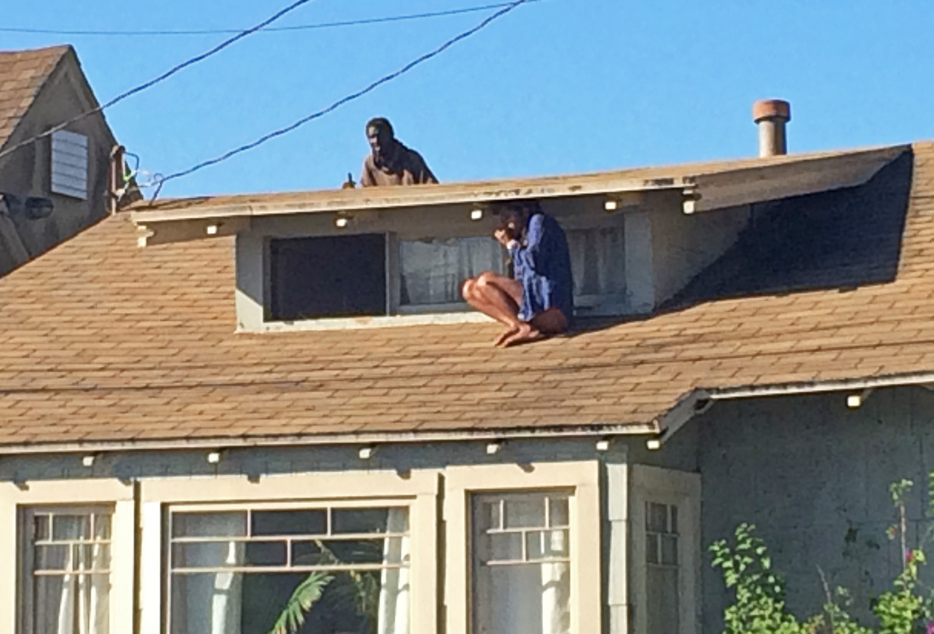 LA woman evades intruder by climbing onto roof