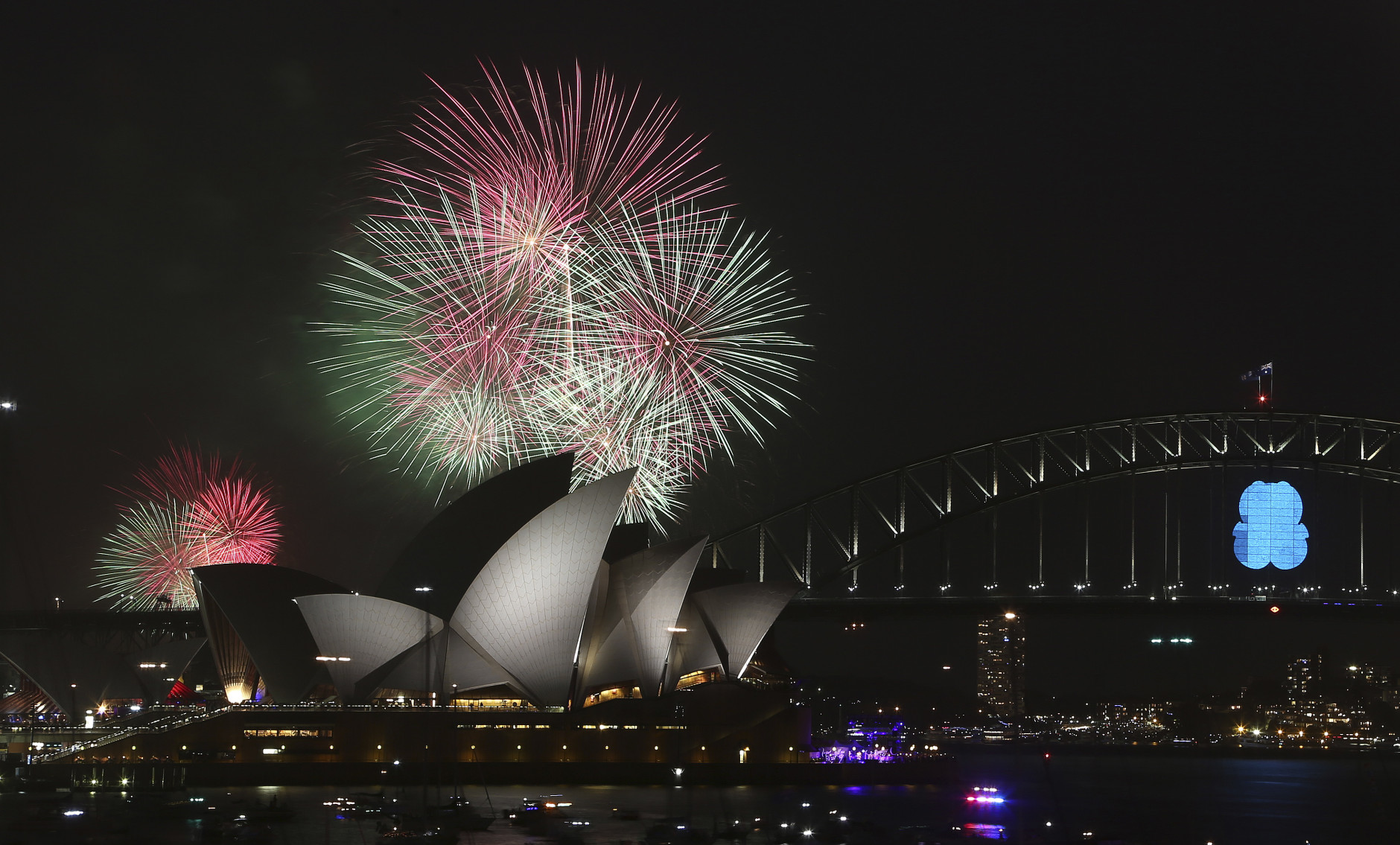 Fireworks explode over the Opera House and the Harbour Bridge during New Years Eve celebrations in Sydney, Australia, Wednesday, Dec. 31, 2014. Thousands of people crammed into Lady Macquaries Chair to watch the annual fireworks show. (AP Photo/Rob Griffith)