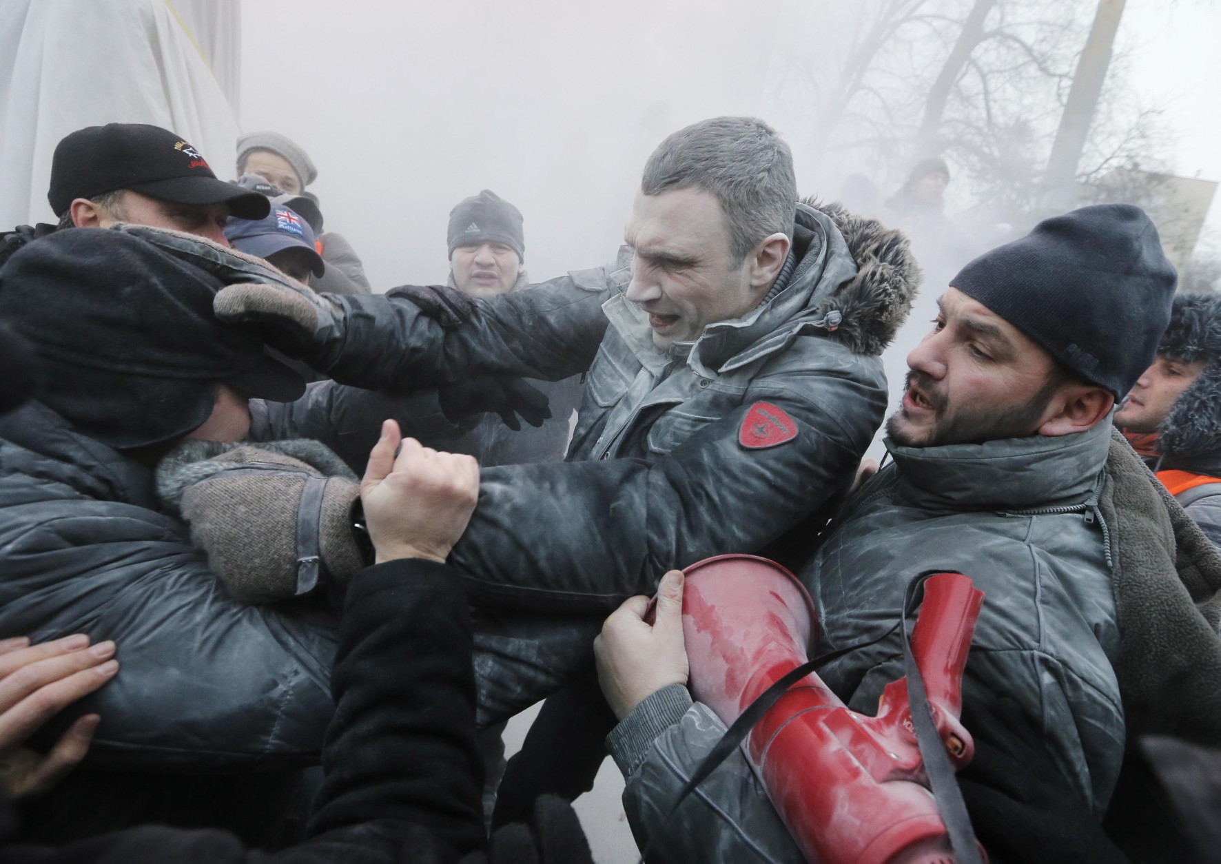 FOR USE AS DESIRED, YEAR END PHOTOS - FILE - Opposition leader and former WBC heavyweight boxing champion Vitali Klitschko, center, is attacked and sprayed with a fire extinguisher as he tries to stop the clashes between police and protesters  in central Kiev, Ukraine, Sunday, Jan. 19, 2014. (AP Photo/Efrem Lukatsky, File)