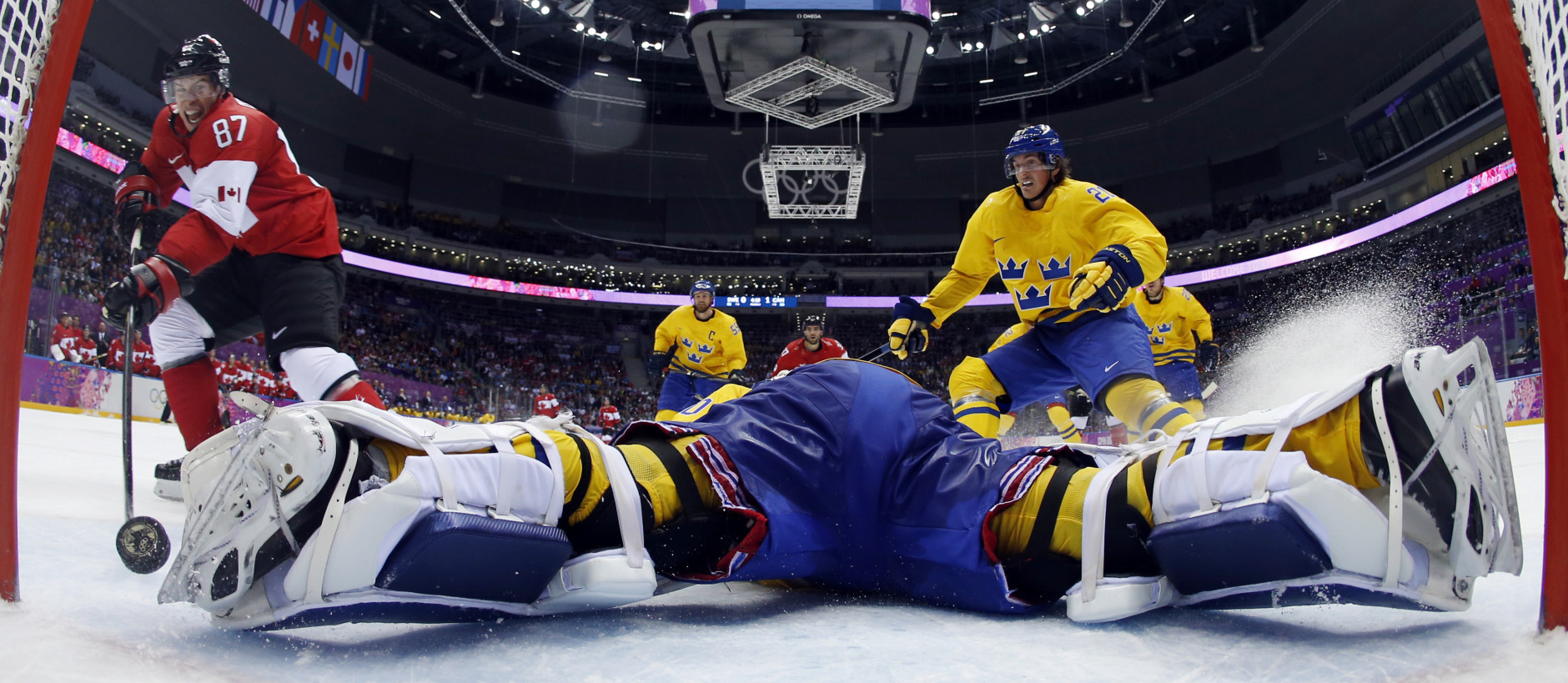 FOR USE AS DESIRED, YEAR END PHOTOS - FILE - Canada forward Sidney Crosby scores a goal on Sweden goaltender Henrik Lundqvist during the second period of the men's gold medal ice hockey game at the 2014 Winter Olympics, Sunday, Feb. 23, 2014, in Sochi, Russia. (AP Photo/Julio Cortez, Pool, File)