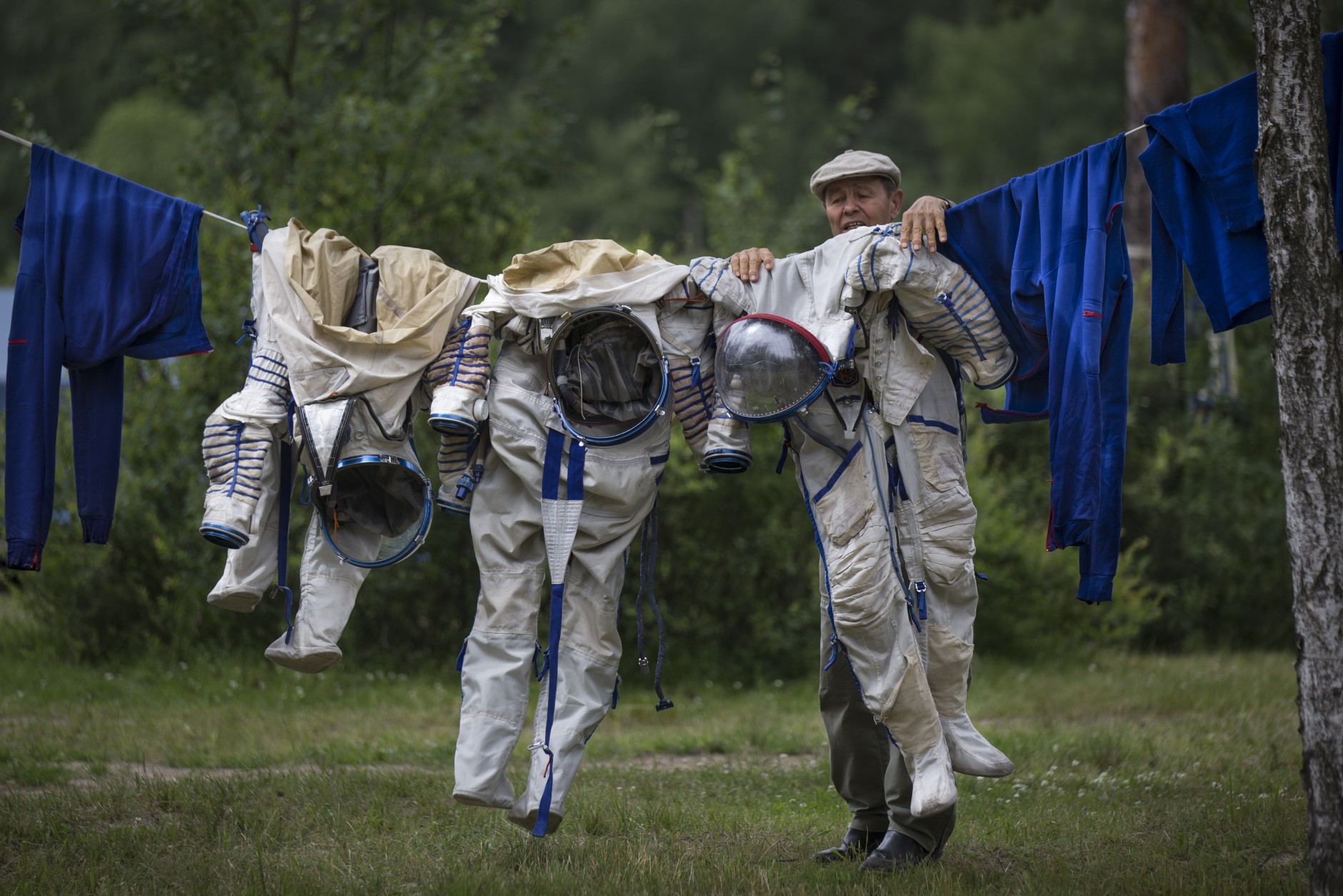 FOR USE AS DESIRED, YEAR END PHOTOS - FILE - An employee of the Russian Space Training Center hangs out space suits to dry of Russian cosmonaut Anatoly Ivanishin, NASA's U.S. flight engineer Kathleen Rubins and Japanese space agency's flight engineer Takuya Onishi after their undergoing training near in Noginsk, 60 km (38 miles) east of Moscow, Russia, Wednesday, July 2, 2014. The training was intended to simulate the capsule landing on water. (AP Photo/Alexander Zemlianichenko, File)