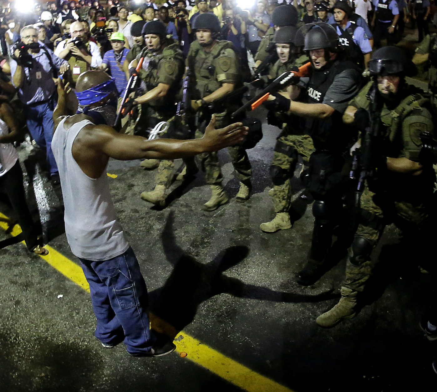 FOR USE AS DESIRED, YEAR END PHOTOS - FILE - Police arrest a man as they disperse a protest in Ferguson, Mo., early Wednesday, Aug. 20, 2014. On Saturday, Aug. 9, a white police officer fatally shot unarmed 18-year-old Michael Brown, who was black, in the St. Louis suburb. (AP Photo/Charlie Riedel, File)