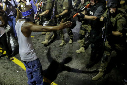 FOR USE AS DESIRED, YEAR END PHOTOS - FILE - Police arrest a man as they disperse a protest in Ferguson, Mo., early Wednesday, Aug. 20, 2014. On Saturday, Aug. 9, a white police officer fatally shot unarmed 18-year-old Michael Brown, who was black, in the St. Louis suburb. (AP Photo/Charlie Riedel, File)