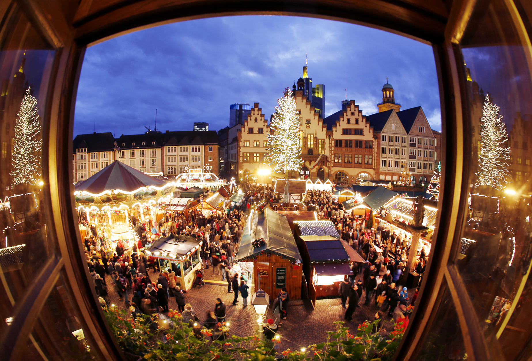 FILE - In this Saturday, Dec. 20, 2014 file photo, taken with a fisheye lens people gather on the traditional Christmas Market in Frankfurt, Germany. The market that runs until next Monday lures every year thousands of tourists. (AP Photo/Michael Probst, File)