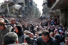 FOR USE AS DESIRED, YEAR END PHOTOS - FILE - This picture taken on Jan. 31, 2014, and released by the UNRWA, shows residents of the besieged Palestinian camp of Yarmouk, queuing to receive food supplies, in Damascus, Syria. A United Nations official called on warring sides in Syria to allow aid workers to resume distribution of food and medicine in a besieged Palestinian district of Damascus. The call comes as U.N. Secretary General Ban Ki-Moon urged Syrian government to authorize more humanitarian staff to work inside the country, devastated by its 3-year-old conflict. (AP Photo/UNRWA, File)