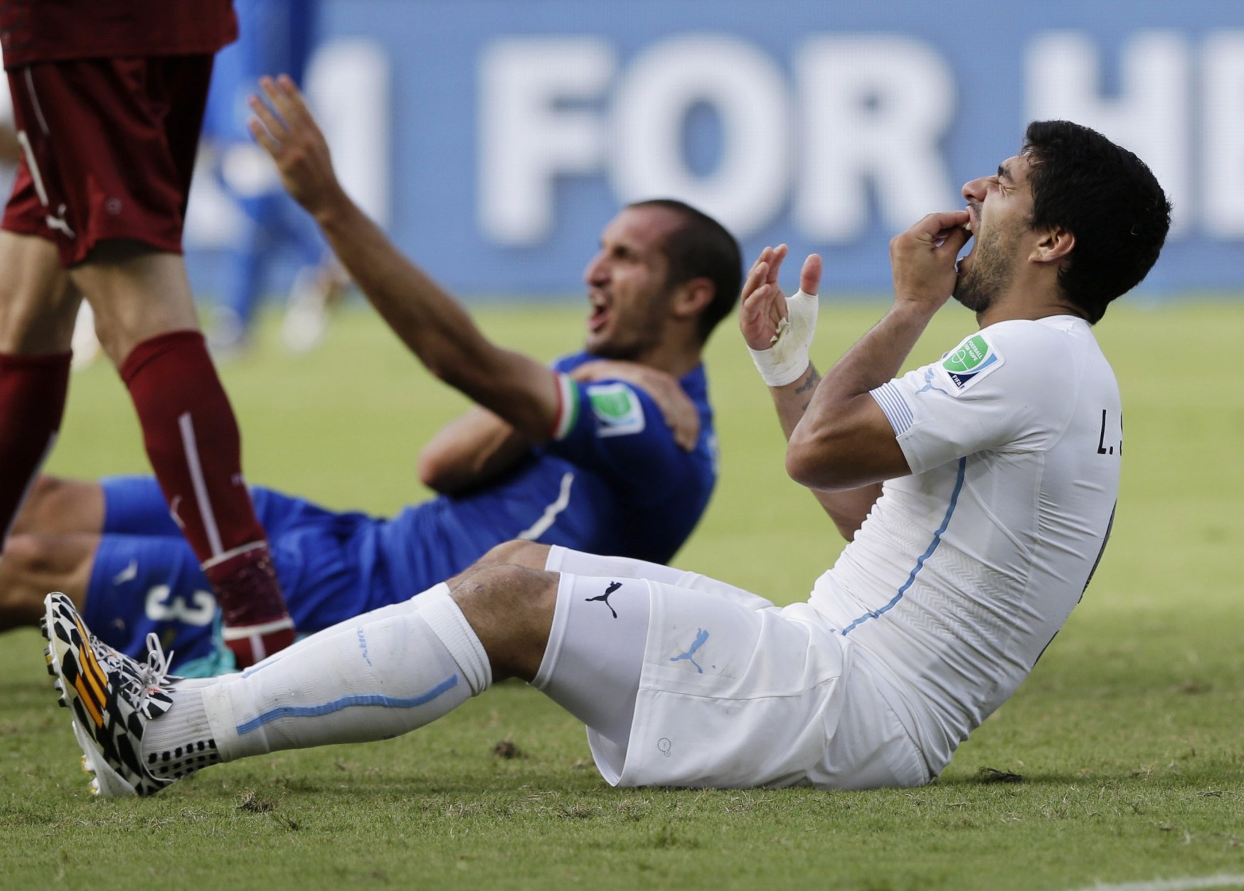 FOR USE AS DESIRED, YEAR END PHOTOS - FILE - Uruguay's Luis Suarez holds his teeth after running into Italy's Giorgio Chiellini's shoulder during the group D World Cup soccer match between Italy and Uruguay at the Arena das Dunas in Natal, Brazil, Tuesday, June 24, 2014. (AP Photo/Ricardo Mazalan, File)