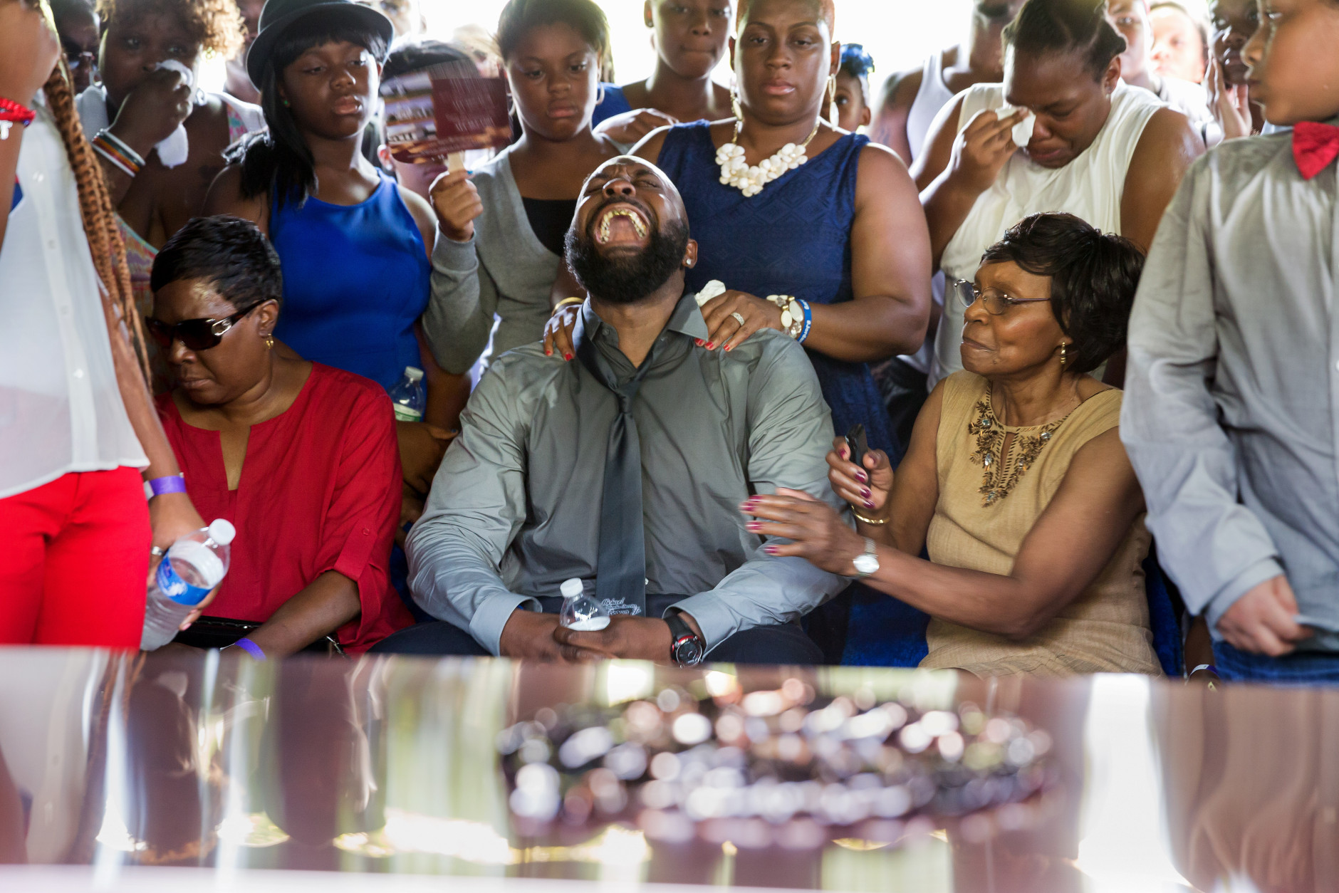 FOR USE AS DESIRED, YEAR END PHOTOS - FILE - Michael Brown Sr. yells out as the casket is lowered during the funeral service for his son Michael Brown in Normandy, Mo., Monday, Aug. 25, 2014. Hundreds of people gathered to say goodbye to Michael Brown, the 18-year-old shot and killed Aug. 9 in a confrontation with a police officer that fueled almost two weeks of street protests. (AP Photo/New York Times, Richard Perry, File Pool)