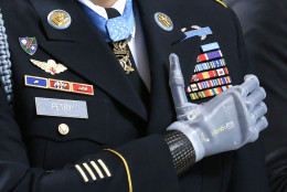 FOR USE AS DESIRED, YEAR END PHOTOS - FILE - Medal of Honor recipient Sgt. 1st Class Leroy Petry stands with his prosthetic hand over his heart, wearing his Medal of Honor during the &quot;Pledge of Allegiance&quot; at the Capitol in Olympia, Wash. on Wednesday, April 2, 2014, during a ceremony to honor him and other recipients of the Medal of Honor from Washington state. Petry lost his hand in 2008 when an enemy grenade he was throwing away from fellow soldiers detonated while in combat in Afghanistan. (AP Photo/Ted S. Warren, File)