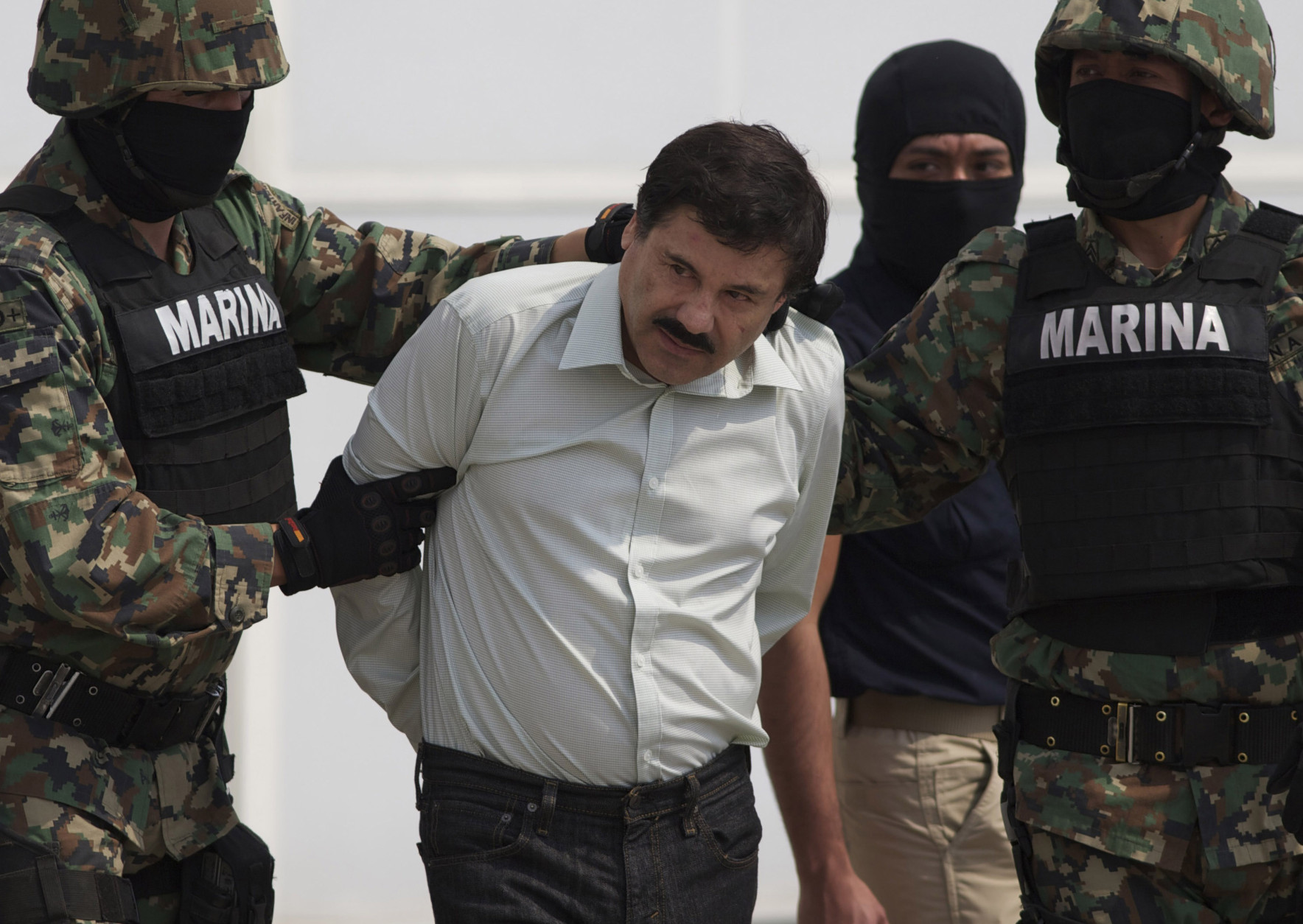 FOR USE AS DESIRED, YEAR END PHOTOS - FILE - In this Saturday, Feb. 22, 2014 photo, Joaquin &quot;El Chapo&quot; Guzman is escorted to a helicopter in handcuffs by Mexican navy marines at a navy hanger in Mexico City, Mexico. Guzman, the head of Mexico's Sinaloa Cartel, was captured alive overnight in the beach resort town of Mazatlan. (AP Photo/Eduardo Verdugo, File)