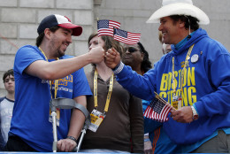FOR USE AS DESIRED, YEAR END PHOTOS - FILE - Holding American flags, Boston Marathon bombing survivor Jeff Bauman, left, bumps fists with Carlos Arredondo near the finish line of the the 118th Boston Marathon, Monday, April 21, 2014, in Boston. (AP Photo/Elise Amendola, File)