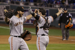 FILE - In this Oct. 29, 2014, file photo, San Francisco Giants pitcher Madison Bumgarner, left, and Buster Posey celebrate after winning 3-2 to win the series over Kansas City Royals after Game 7 of baseball's World Series in Kansas City, Mo. (AP Photo/Matt Slocum, File)