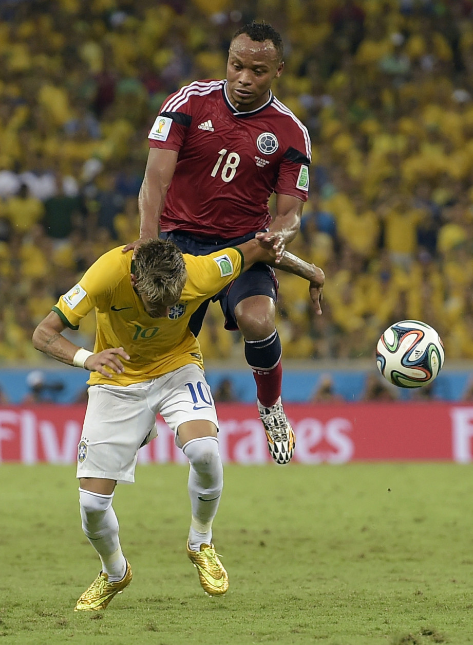 FOR USE AS DESIRED, YEAR END PHOTOS - FILE - Brazil's Neymar is fouled by Colombia's Juan Zuniga during the World Cup quarterfinal soccer match between Brazil and Colombia at the Arena Castelao in Fortaleza, Brazil, Friday, July 4, 2014. Brazil's team doctor says Neymar will miss the rest of the World Cup after breaking a vertebrae during the team's quarterfinal win over Colombia. (AP Photo/Manu Fernandez, File)