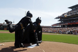 FOR USE AS DESIRED, YEAR END PHOTOS - FILE - Miles Scott, left, dressed as Batkid, throws the ceremonial first pitch next to Batman before an opening day baseball game between the San Francisco Giants and the Arizona Diamondbacks in San Francisco, Tuesday, April 8, 2014. On Nov. 15, 2013, Scott, a Northern California boy with leukemia, fought villains and rescued a damsel in distress as a caped crusader through The Greater Bay Area Make-A-Wish Foundation. (AP Photo/Eric Risberg, Pool, File)