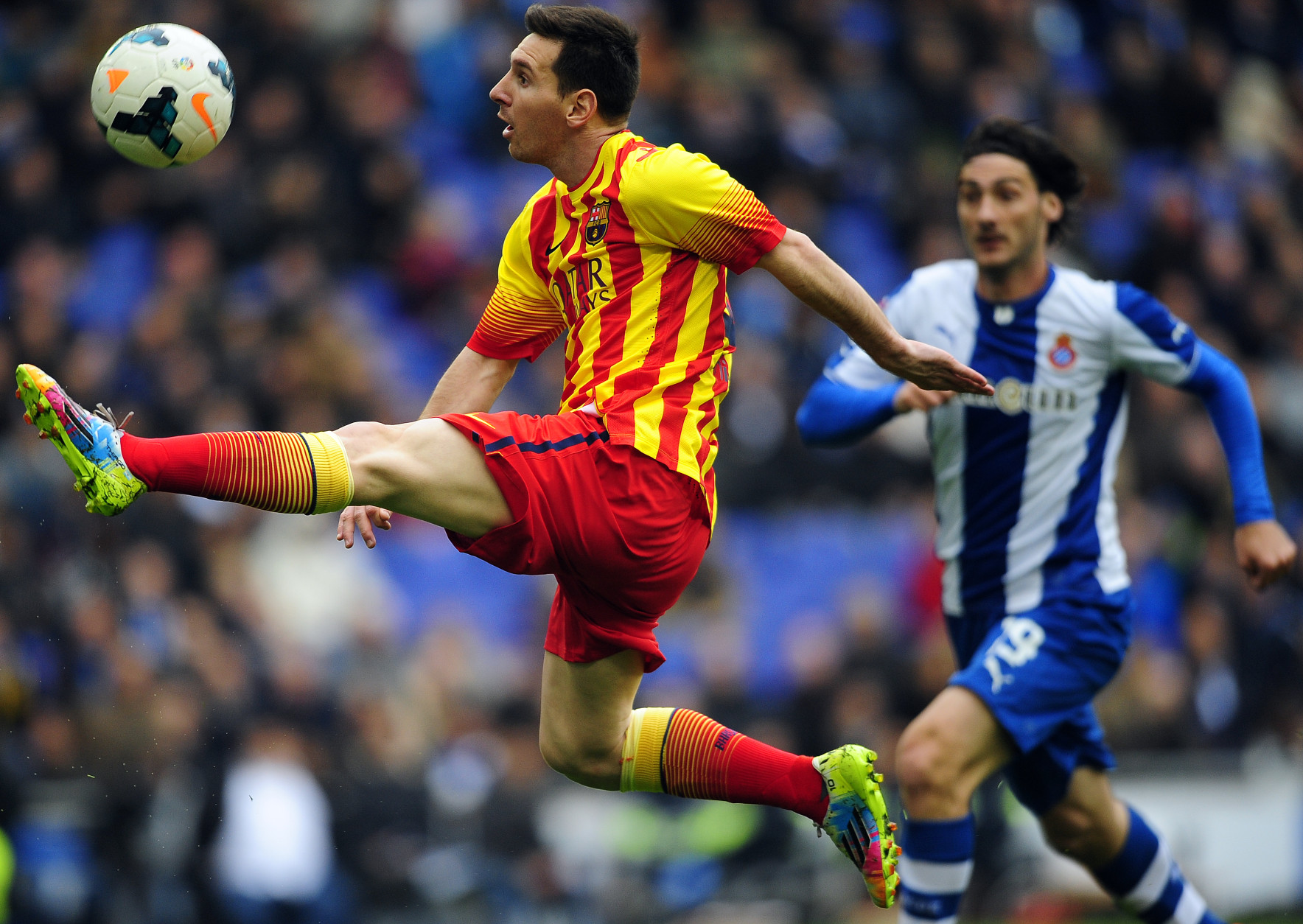 FOR USE AS DESIRED, YEAR END PHOTOS - FILE - FC Barcelona's Lionel Messi, left, duels for the ball against Espanyol's Diego Colotto during a Spanish La Liga soccer match against Espanyol at Cornella-El Prat stadium in Cornella Llobregat, Spain, Saturday, March 29, 2014. (AP Photo/Manu Fernandez, File)