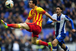 FOR USE AS DESIRED, YEAR END PHOTOS - FILE - FC Barcelona's Lionel Messi, left, duels for the ball against Espanyol's Diego Colotto during a Spanish La Liga soccer match against Espanyol at Cornella-El Prat stadium in Cornella Llobregat, Spain, Saturday, March 29, 2014. (AP Photo/Manu Fernandez, File)