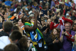 FOR USE AS DESIRED, YEAR END PHOTOS - FILE - Usain Bolt of Jamaica takes a photo on a smart phone with a member of the crowd as he walks round Hampden Park Stadium after he competed in the men's 4x100 meter relay race during the Commonwealth Games 2014 in Glasgow, Scotland, Saturday Aug. 2, 2014. (AP Photo/ Scott Heppell, File)