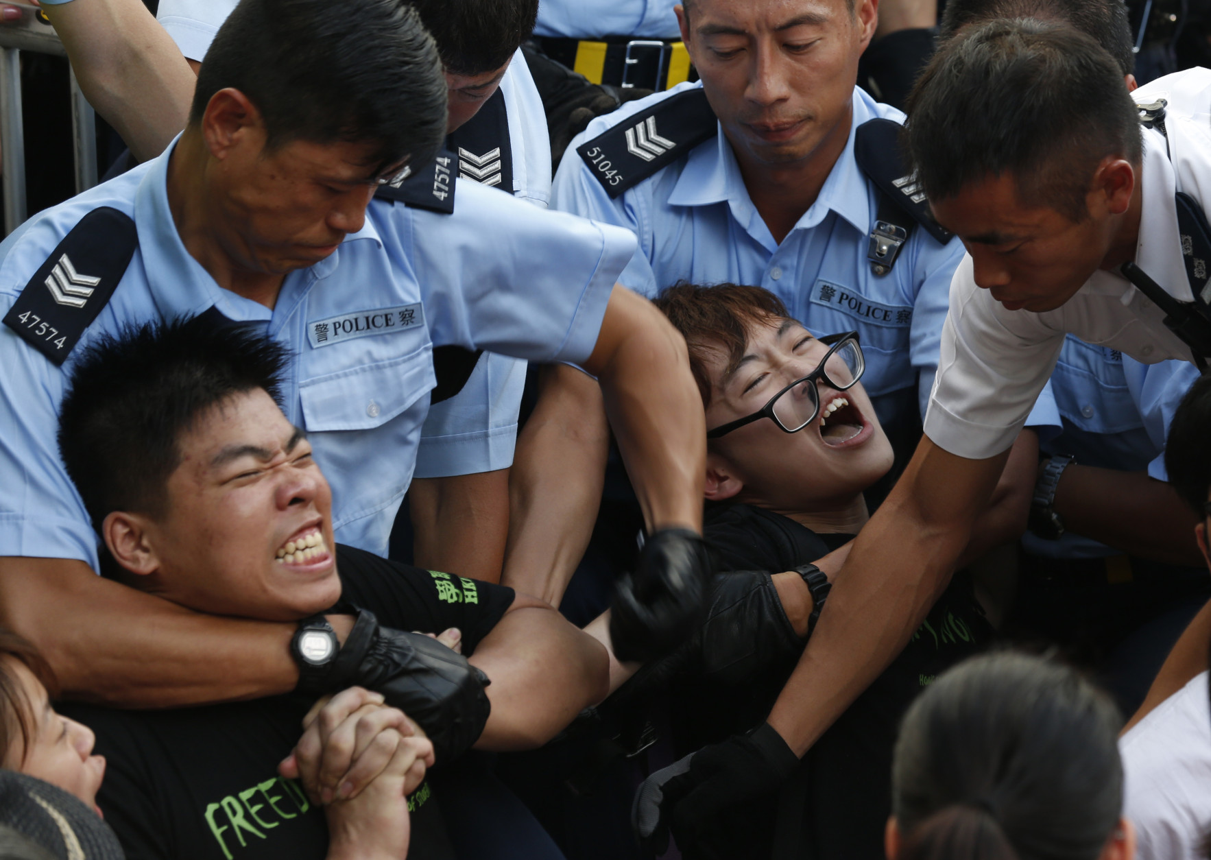 FOR USE AS DESIRED, YEAR END PHOTOS - FILE - Protesters are taken away by police officers after hundreds of protesters staged a peaceful sit-ins overnight on a street in the financial district in Hong Kong Wednesday, July 2, 2014, following a huge rally to show their support for democratic reform and oppose Beijing's desire to have the final say on candidates for the chief executive's job. (AP Photo/Kin Cheung, File)
