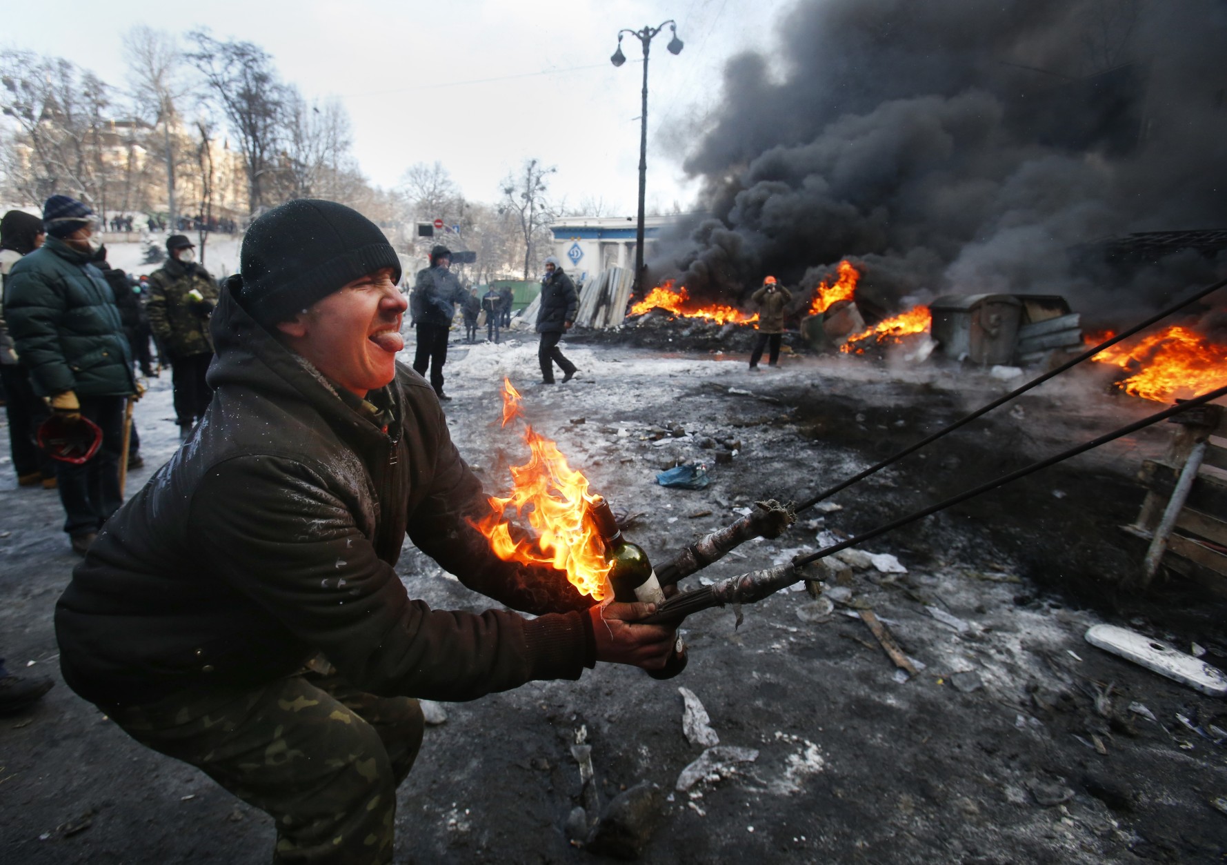 FOR USE AS DESIRED, YEAR END PHOTOS - FILE - Protesters use a large slingshot to hurl a Molotov cocktail at police in central Kiev, Ukraine, Thursday Jan. 23, 2014. (AP Photo/Sergei Grits, File)