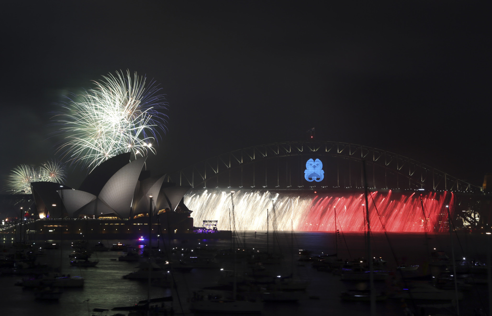 Fireworks explode over the Opera House and the Harbour Bridge during New Years Eve celebrations in Sydney, Australia, Wednesday, Dec. 31, 2014. Thousands of people crammed into Lady Macquaries Chair to watch the annual fireworks show. (AP Photo/Rob Griffith)