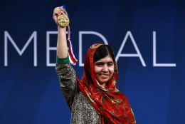 FOR USE AS DESIRED, YEAR END PHOTOS - FILE - Malala Yousafzai holds up her Liberty Medal during a ceremony at the National Constitution Center, Tuesday, Oct. 21, 2014, in Philadelphia. The honor is given annually to an individual who displays courage and conviction while striving to secure liberty for people worldwide. (AP Photo/Matt Rourke, File)