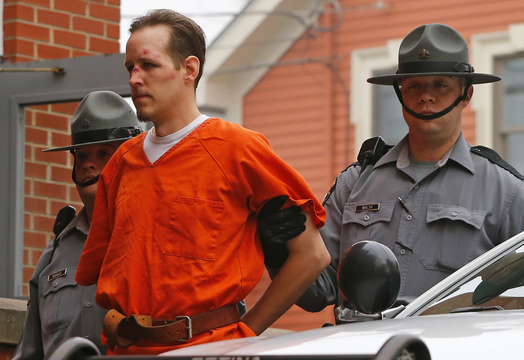 FOR USE AS DESIRED, YEAR END PHOTOS - FILE - Eric Frein is escorted by police into the Pike County Courthouse for his arraignment in Milford, Pa., Friday Oct. 31, 2014. Frein was captured seven weeks after police say he killed a Pennsylvania State trooper in an ambush outside a barracks in northeastern Pennsylvania. (AP Photo/Rich Schultz, File)