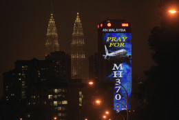 FOR USE AS DESIRED, YEAR END PHOTOS - FILE - An office building is illuminated with LED lights displaying &quot;Pray for MH370&quot; next to Malaysia's landmark Petronas Twin Towers in Kuala Lumpur, Malaysia, Wednesday, March 19, 2014.  (AP Photo/Lai Seng Sin, File)