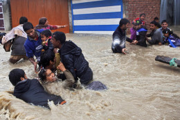 FOR USE AS DESIRED, YEAR END PHOTOS - FILE - Kashmiri residents wade through floodwaters in Srinagar, India, Thursday, Sept. 4, 2014. At least 100 villages across the Kashmir valley were flooded by overflowing lakes and rivers. (AP Photo/Dar Yasin, File)