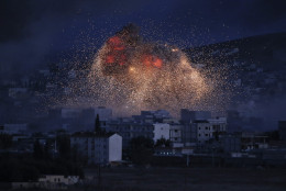 FOR USE AS DESIRED, YEAR END PHOTOS - FILE - Thick smoke and flames from an airstrike by the U.S.-led coalition rise in Kobani, Syria, as seen from a hilltop on the outskirts of Suruc, at the Turkey-Syria border, Monday, Oct. 20, 2014. Kobani, also known as Ayn Arab, and its surrounding areas, has been under assault by extremists of the Islamic State group since mid-September and is being defended by Kurdish fighters. (AP Photo/Lefteris Pitarakis, File)