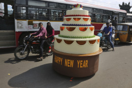 Sudhakar Yadav, the designer of a cake-shaped car, rides it on a street on New Years eve in Hyderabad, India, Wednesday, Dec. 31, 2014. The single seater vehicle is powered by a 100 cc engine from a road sweeping machine and can travel unto 10 kilometers per hour (6 miles per hour). (AP Photo/Mahesh Kumar A.)