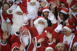Around 250 people dressed in Santa Claus costumes pose for photographers before a parade in the streets of Vallauris, southeastern France, Saturday, Dec. 20, 2014. (AP Photo/Lionel Cironneau)