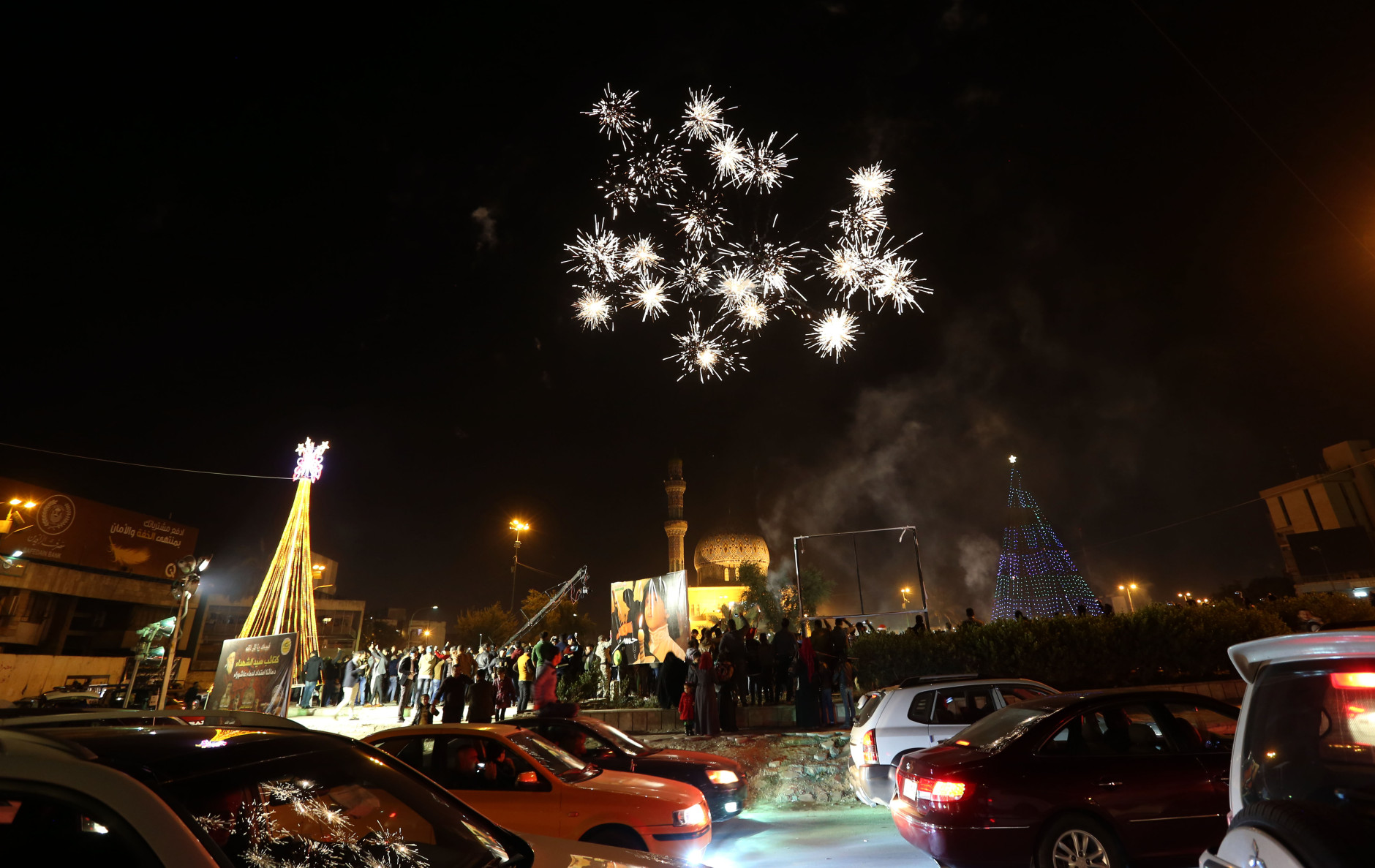 A Iraqi Crowds cheer as the countdown and fireworks begin during a New Year's Day celebration at Firdous Square in Baghdad, Iraq, Wednesday, Dec. 31, 2014. (AP Photo/Hadi Mizban)