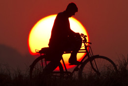 A Pakistani cyclist rides during the last sunset of the year on the outskirts of Islamabad, Pakistan, Wednesday, Dec. 31, 2014. (AP Photo/Anjum Naveed)