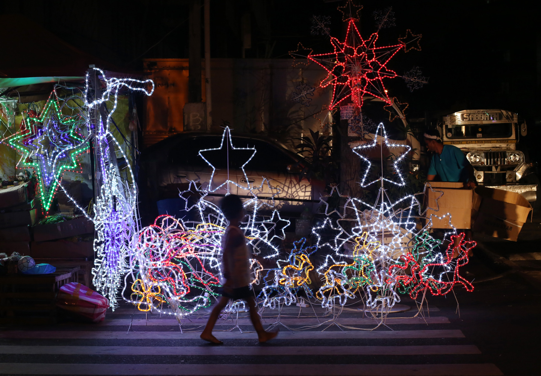 A Filipino boy walks past Christmas decorations for sale in Manila, Philippines on Monday, Dec. 22, 2014. Christmas is one of the most important holidays in this predominantly Roman Catholic nation. (AP Photo/Aaron Favila)