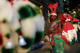 A roadside vendor holds Christmas ornaments and paraphernalia for sale in Mumbai, India, Saturday, Dec 20, 2014. (AP Photo/Rafiq Maqbool)
