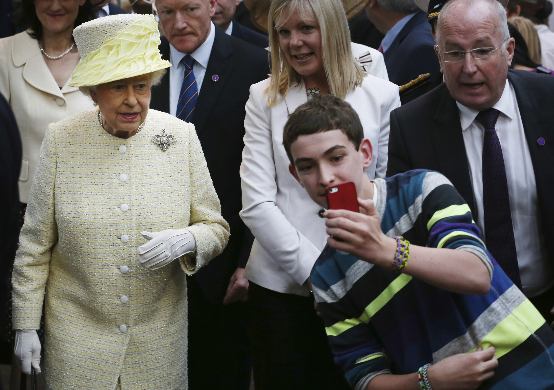 FOR USE AS DESIRED, YEAR END PHOTOS - FILE - A local youth takes a selfie photograph in front of Queen Elizabeth II during a visit to St George's indoor market on  in Belfast Tuesday June 24, 2014. The Queen is on a 3 day visit to Northern Ireland.  (AP Photo/Peter Macdiarmid, File Pool)