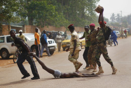 FOR USE AS DESIRED, YEAR END PHOTOS - FILE - GRAPHIC CONTENT - Newly enlisted FACA (Central African Armed Forces) soldiers drag the lifeless body of a suspected Muslim Seleka militiaman moments after Central African Republic Interim President Catherine Samba-Panza addressed the troops in Bangui, Wednesday Feb. 5, 2014. The victim was lynched by hundreds of recruits, pelting him with bricks and mutilating his body with knives. (AP Photo/Jerome Delay, File)